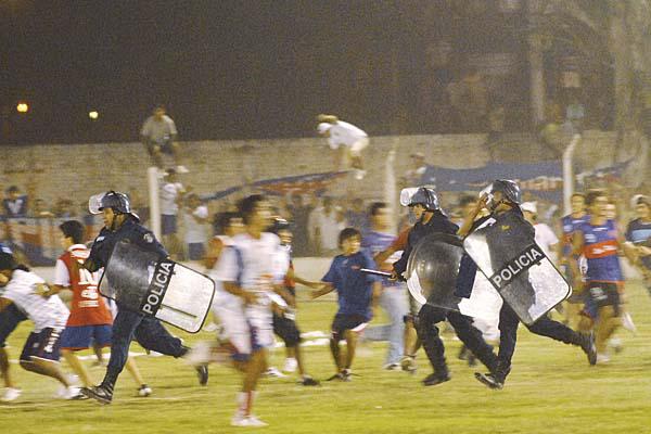 REACCIÓN La hinchada de Güemes invadió el campo de juego ni bien Contreras convirtió el segundo tanto del local La policía reprimió y la batalla campal se desencadenó