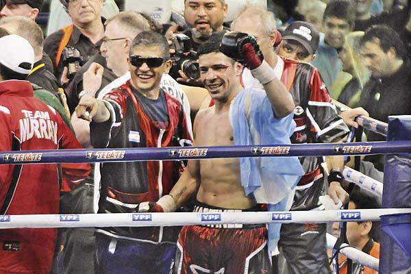 DOLOR El pgil argentino levanta su mano izquierda la que luego se supo que se lesionó gravemente para saludar al pblico tras el extenuante combate