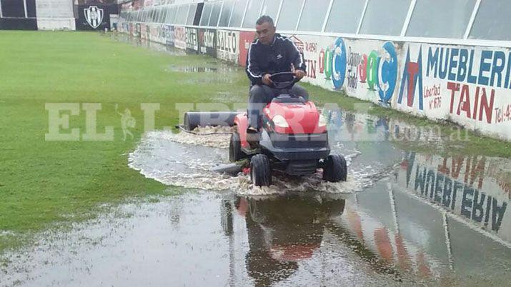 Hinchas solidarios del Ferro sacan el agua de la cancha