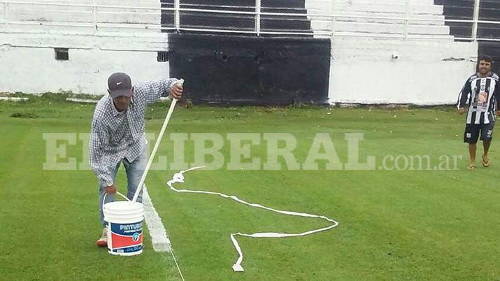 Hinchas solidarios del Ferro sacan el agua de la cancha