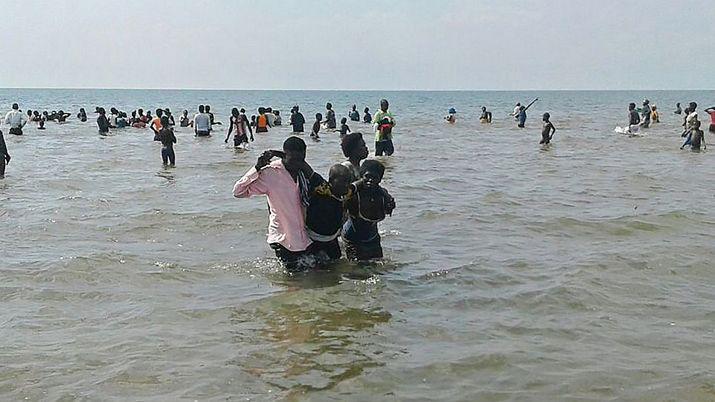 Una de las personas rescatadas siendo llevada a la orilla