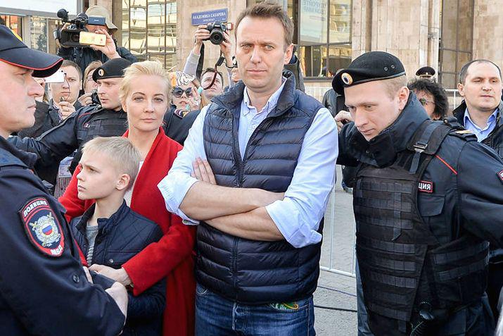 El líder de la oposición Alexei Navalny con su esposa Yulia y su hijo Zahar rodeados de policías en una protesta de mayo ltimo