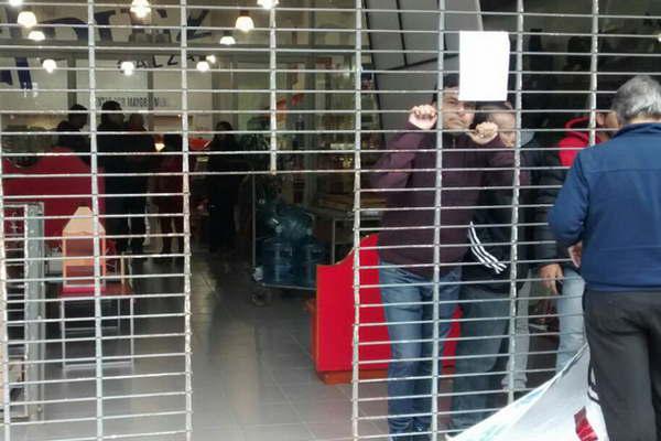 Conflicto laboral en dos zapateriacuteas- piden por sus empleos y salarios atrincherados en la puerta del local