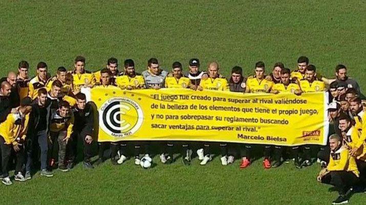 Los jugadores de Comunicaciones y una bandera con una frase de Bielsa