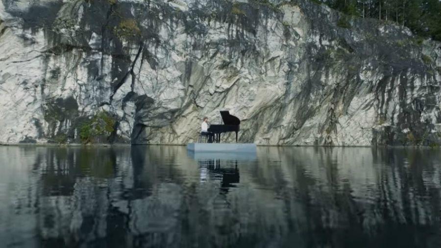 Un pianista toca arriba de una balsa en un lago en Rusia