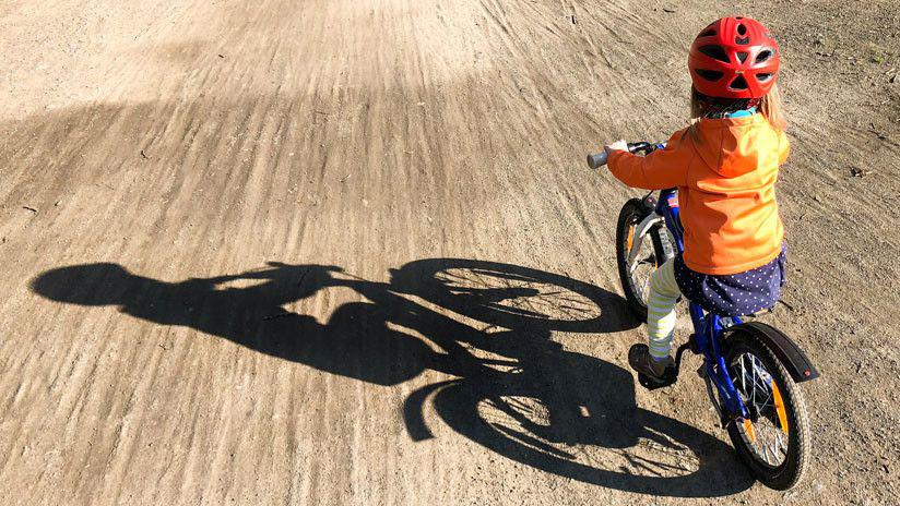 Una nintildea en bicicleta gana una carrera contra un patrullero