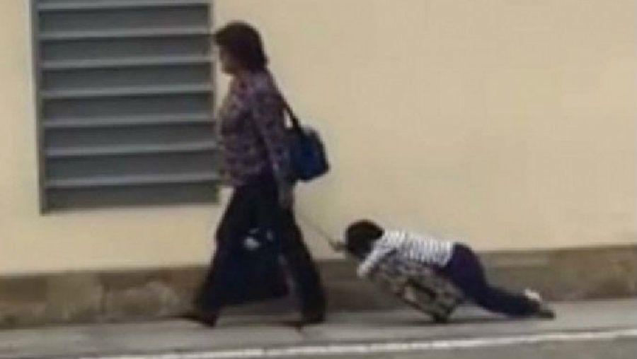 Una madre lleva a su hijo arrastrando al colegio