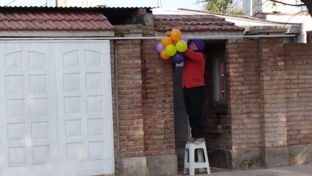 Vecinos agasajan a los nintildeos con globos en el frente de sus casas