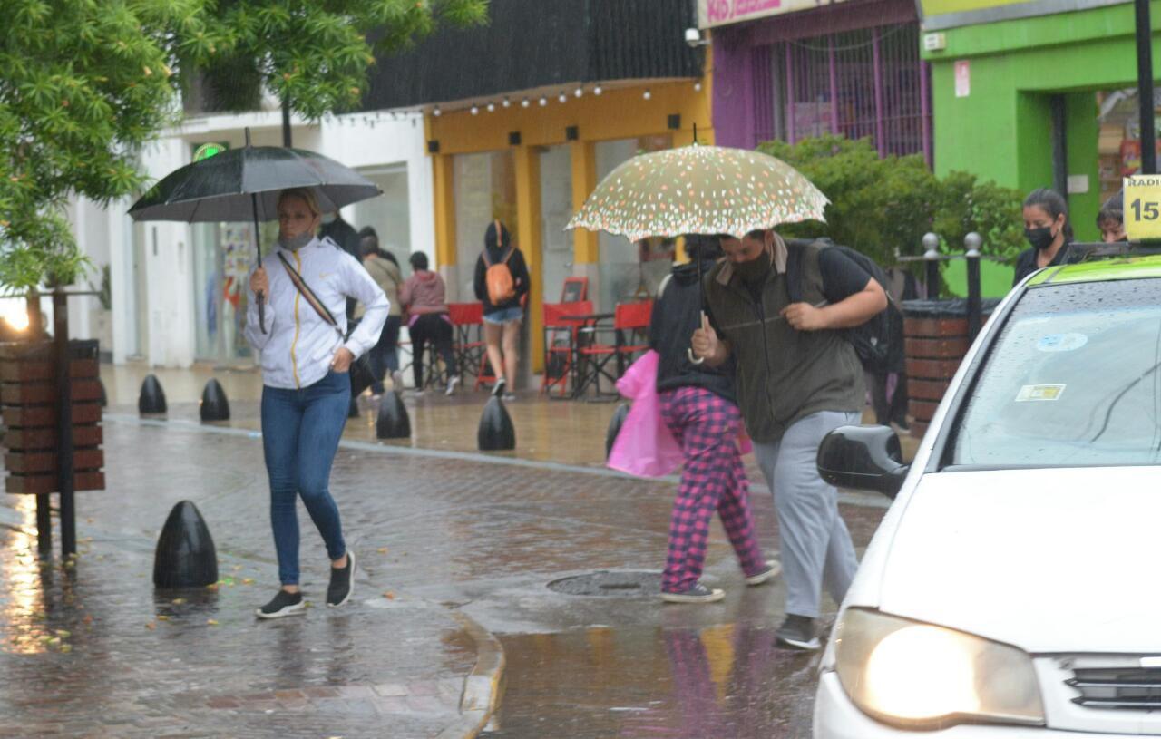 FOTOS  A pesar de la lluvia los santiaguentildeos copan las calles del Centro