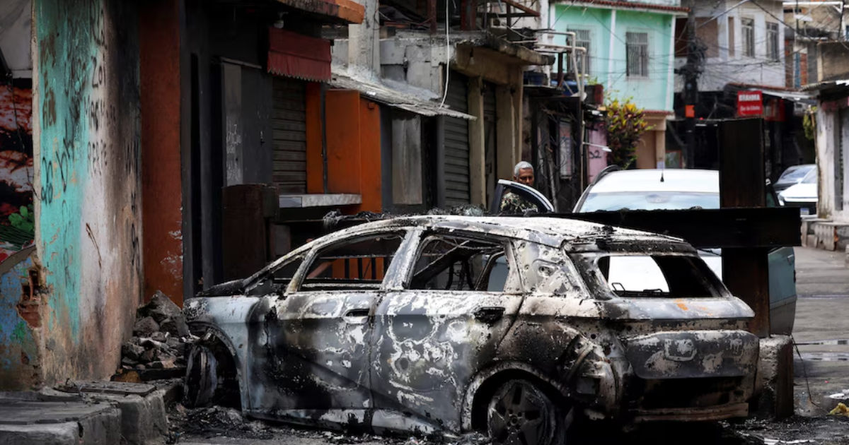 Una persona mira detrs de un coche quemado durante una operación policial contra el trfico de drogas en la favela do Penha en Río de Janeiro (REUTERSAline Massuca)